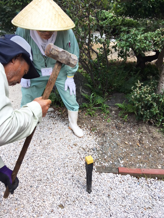 黄色の境界杭を打ち付ける写真