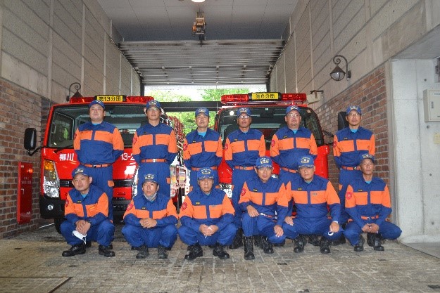 消防車の前に集まる消防団員の写真2