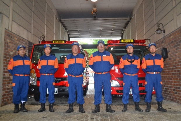 消防車の前に集まる消防団員の写真3