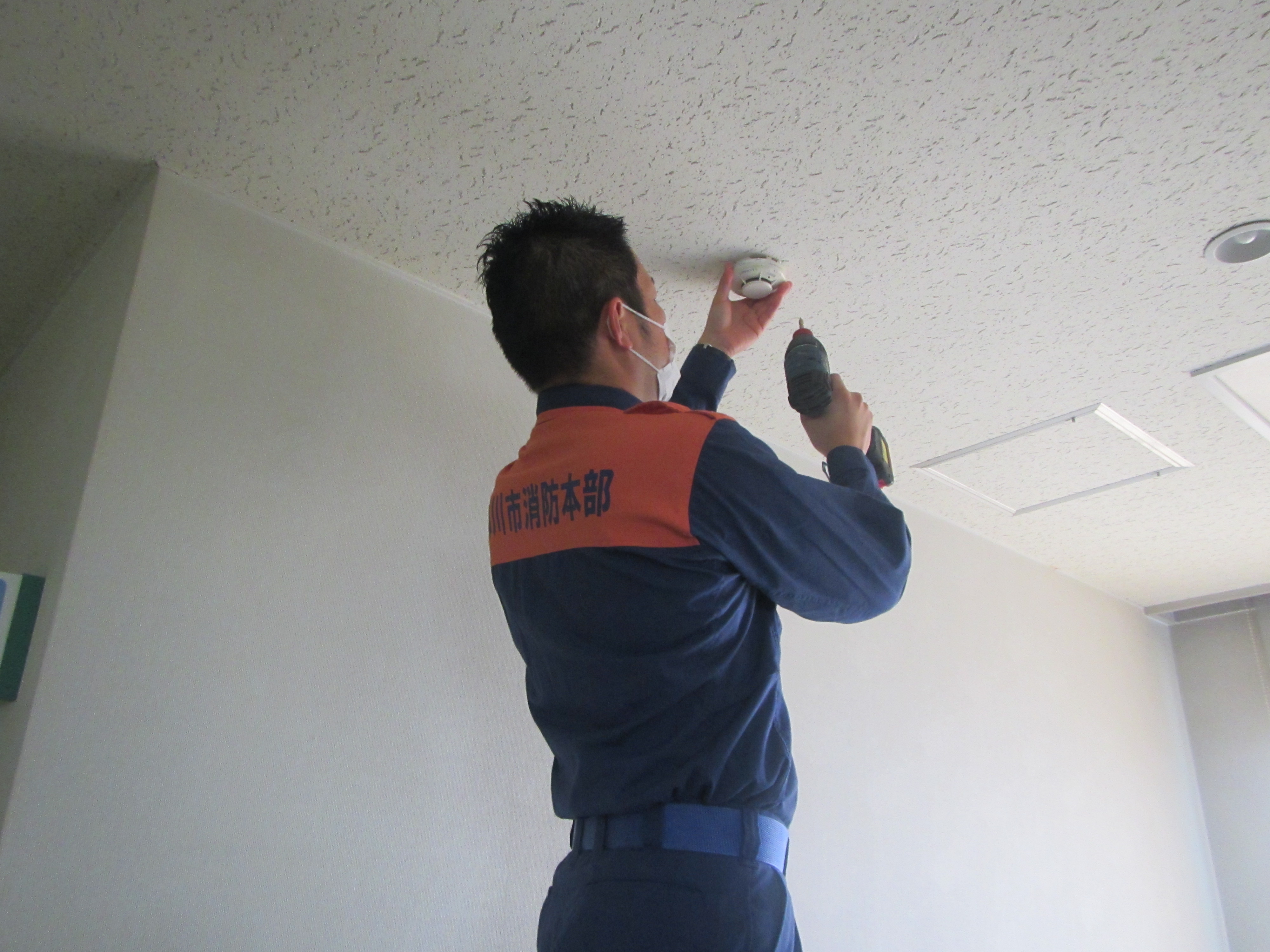 住宅用火災警報器を設置する消防職員の様子